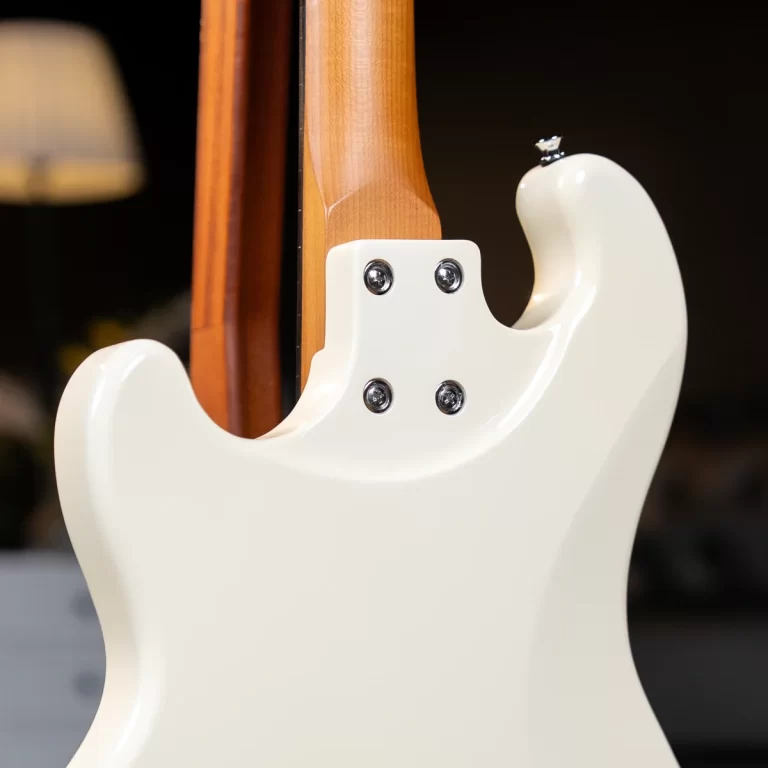 Close-up of a white electric guitar where the maple neck is bolted to the body with four screws at the neck joint ขายราคาพิเศษ