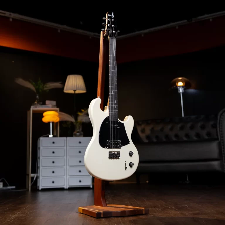 White electric guitar on a wooden stand in a dim, cozy living room/studio with a dresser, lamp, and sofa in the background ขายราคาพิเศษ
