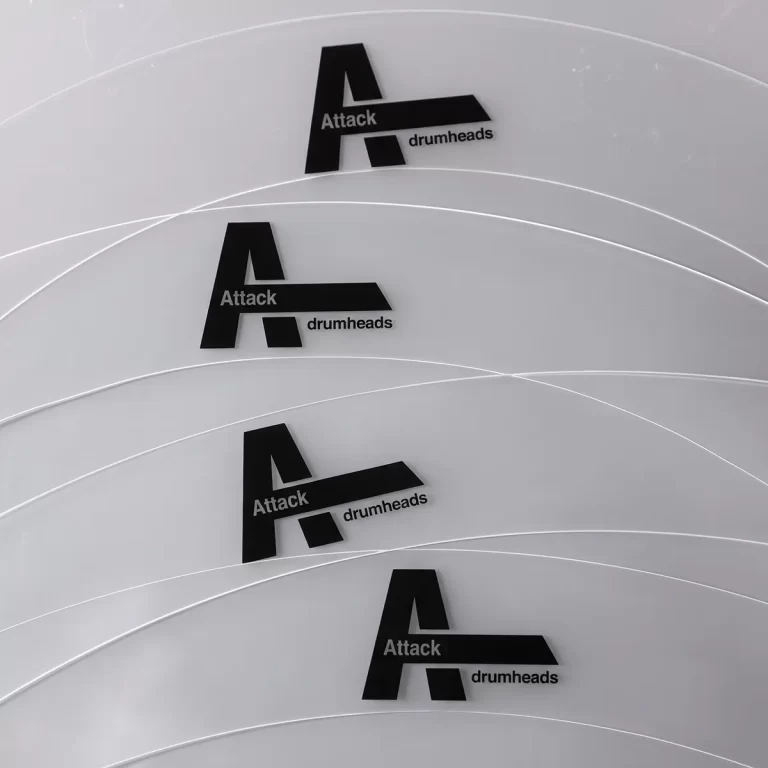 Repeating Attack Drumheads logo on light gray curved surfaces (drumheads). ขายราคาพิเศษ