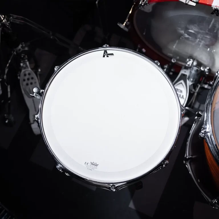 Close-up of a white bass drum head with chrome rim, part of a drum kit. ขายราคาพิเศษ