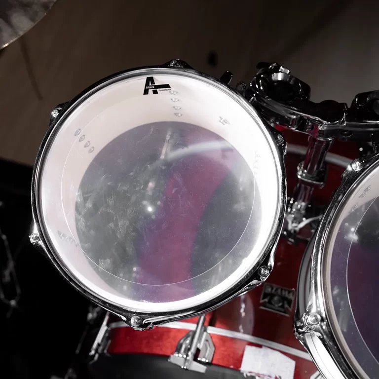 Close-up of a red drum with a clear drumhead and chrome hardware, featuring the Attack logo near the rim. ขายราคาพิเศษ