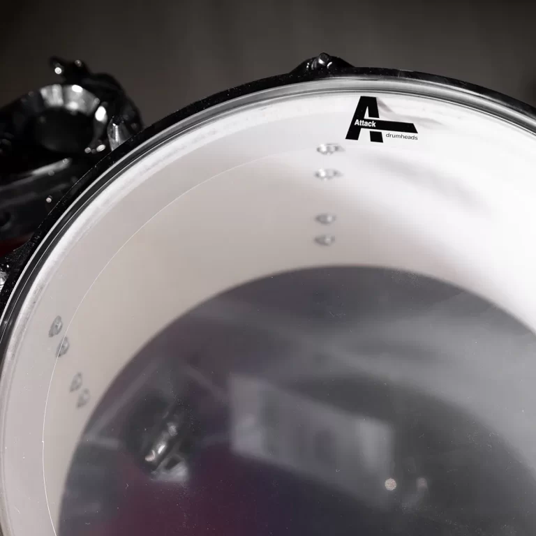 Close-up of a white drum head with the Attack drumheads logo visible near the rim. ขายราคาพิเศษ