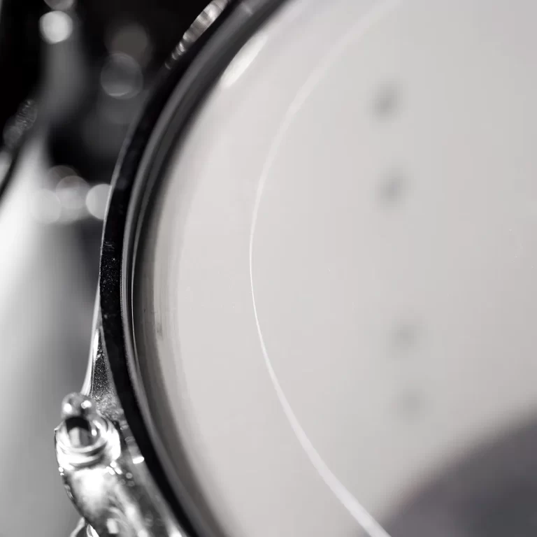 Close-up of a shiny drum rim and white drumhead with blurred background. ขายราคาพิเศษ