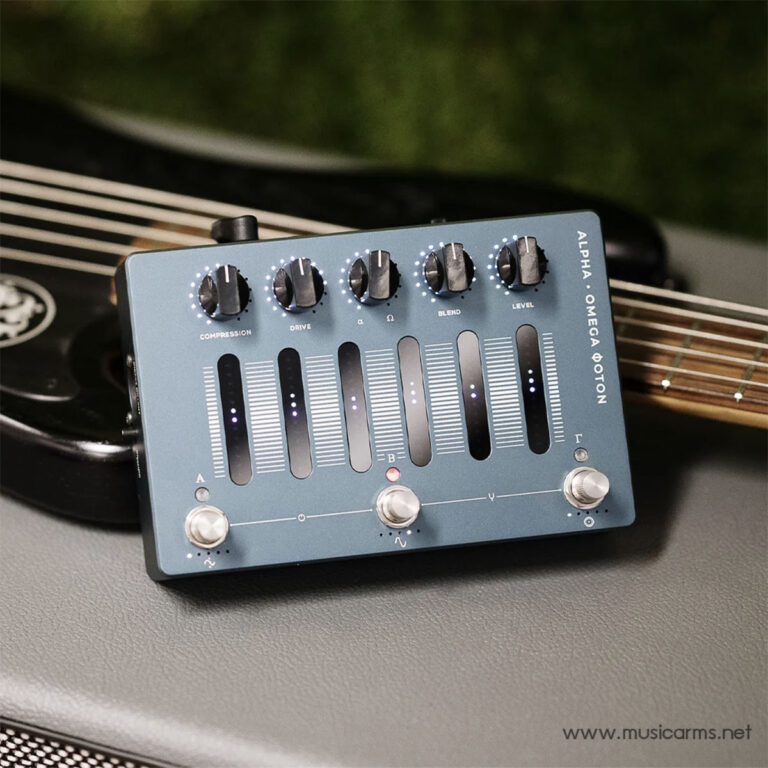 Close-up of a blue guitar effects pedal with multiple sliders and knobs on top, resting on a guitar. It shows controls for compression, drive, blend and level. ขายราคาพิเศษ