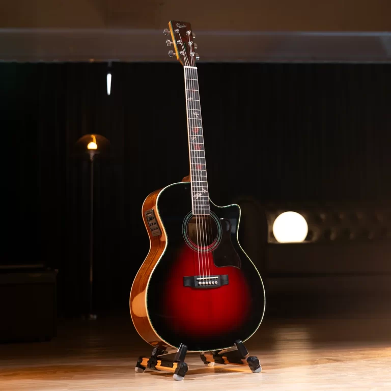 Sunburst acoustic guitar on a stand under warm stage lighting in a dark rehearsal space, ready to play ขายราคาพิเศษ
