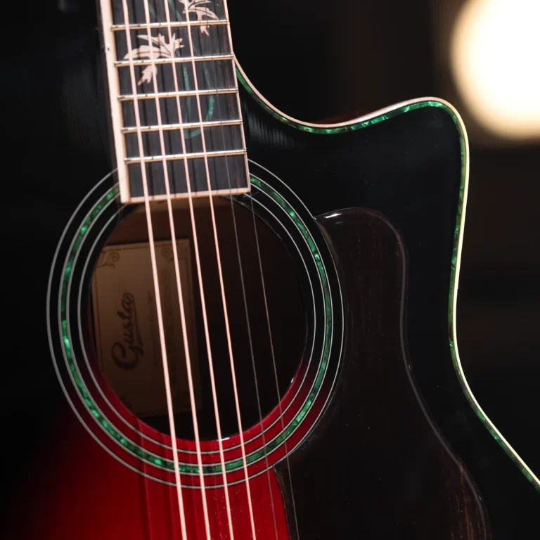Close-up of a glossy black acoustic guitar body with green binding and soundhole rosette, showing strings and part of the fretboard. ขายราคาพิเศษ