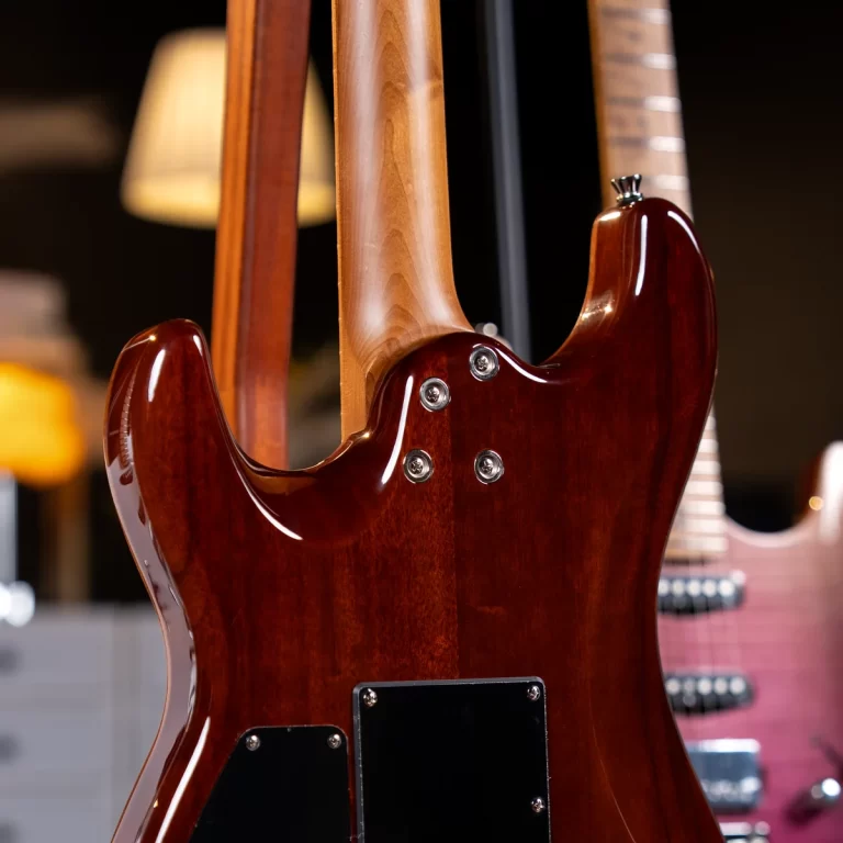 Close-up of a glossy cherry-red electric guitar back with neck attached and chrome screws, in a showroom setting. ขายราคาพิเศษ