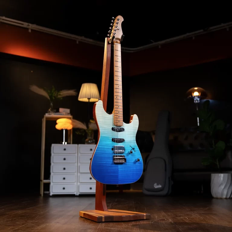 Blue electric guitar with a blue gradient finish on a wooden stand in a dim studio room with furniture in the background ขายราคาพิเศษ