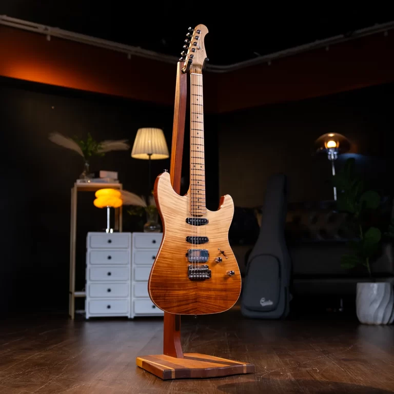 Electric guitar on a wooden stand in a cozy, dimly lit studio with a white dresser, lamp, and a guitar case in the background. ขายราคาพิเศษ