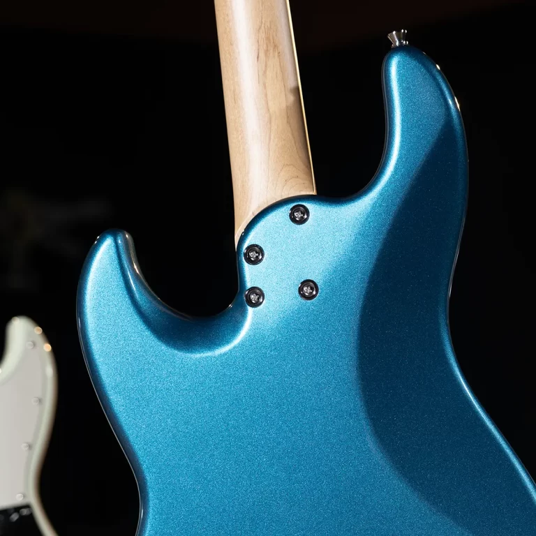 Teal-blue electric guitar body with a maple neck bolted at the back, close-up of the neck joint and screws against a dark background ขายราคาพิเศษ