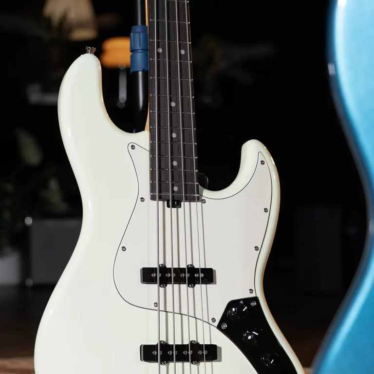 Close-up of a white electric bass guitar with a black pickguard and four strings. ขายราคาพิเศษ