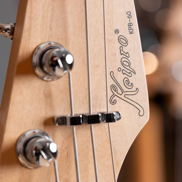 Close-up of a Fender guitar headstock showing tuning pegs and strings, wood grain visible. ขายราคาพิเศษ