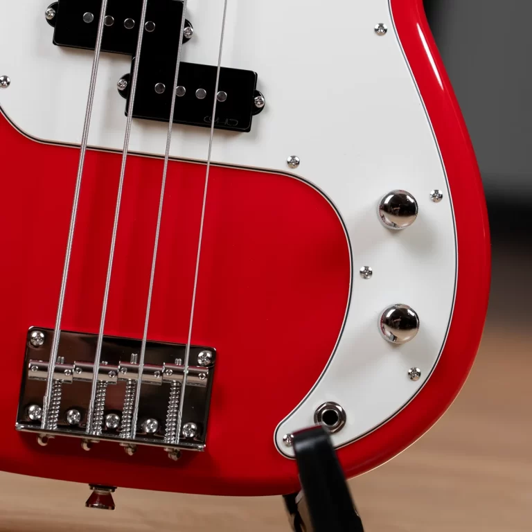 Close-up of a red electric guitar body with a white pickguard, chrome strings and hardware. ขายราคาพิเศษ