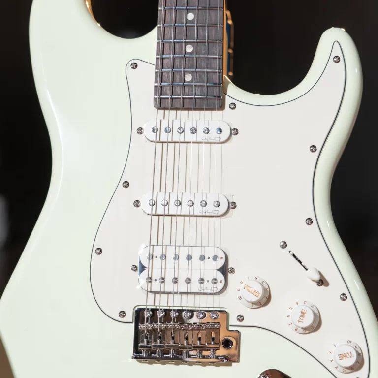 Light green Fender-style Stratocaster guitar with white pickguard, three pickups, and chrome bridge shown close-up on black background. ขายราคาพิเศษ