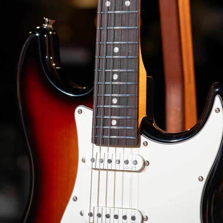 Close-up of a sunburst electric guitar, showcasing the fretboard, pickups, and white pickguard ขายราคาพิเศษ