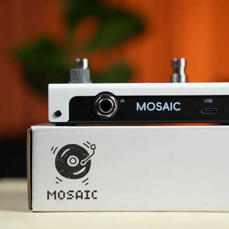Close-up of a MOSAIC guitar pedal resting on its white packaging, with the MOSAIC logo visible on the side panel. ขายราคาพิเศษ