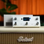 White guitar effects processor with LCD screen showing P18, three footswitches labeled A, B, C, and two knobs on a speaker cabinet top. ลดราคาพิเศษ