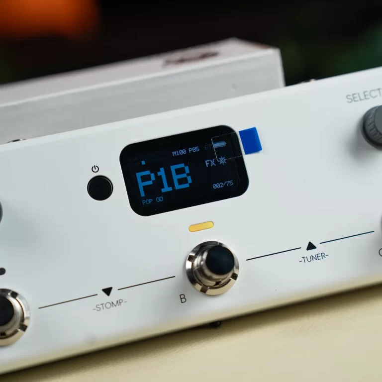 Close-up of a white guitar effects unit with a blue digital display showing 'P18' and labeled knobs like STOMP and TUNER on the panel. ขายราคาพิเศษ