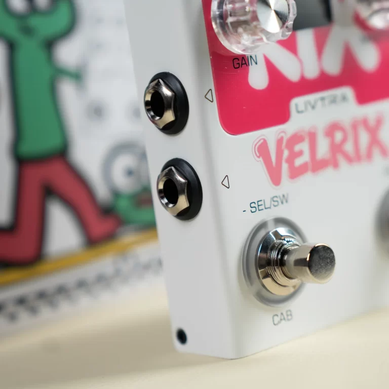 Close-up of a white guitar effects pedal showing two side input jacks, a silver footswitch labeled CAB, and a pink gain panel with a knob. ขายราคาพิเศษ