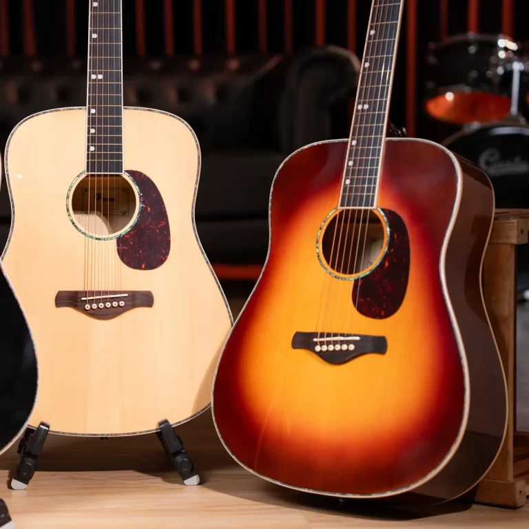 Two acoustic guitars on stands in a music shop, one natural wood and one sunburst finish. ขายราคาพิเศษ