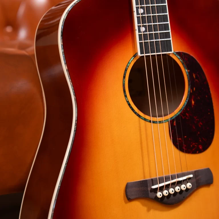 Close-up of an acoustic guitar with a sunburst finish, showing the soundhole, strings, and bridge. ขายราคาพิเศษ