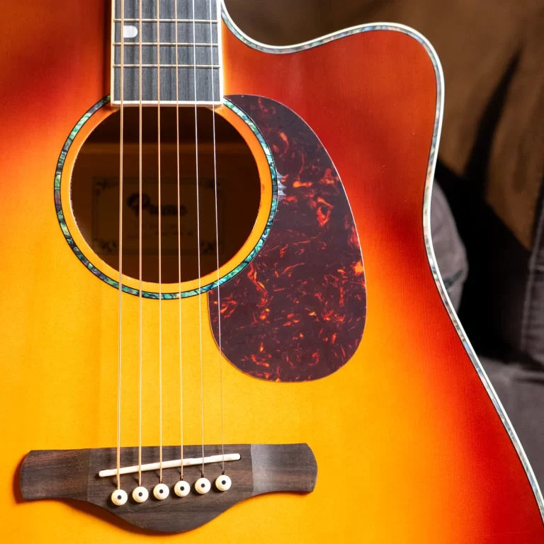 Close-up of a sunburst acoustic guitar with sound hole, tortoise pickguard, and six strings on the body surface. ขายราคาพิเศษ