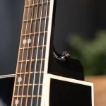 Close-up of a guitar neck showing frets and copper strings against a dark body. ขายราคาพิเศษ