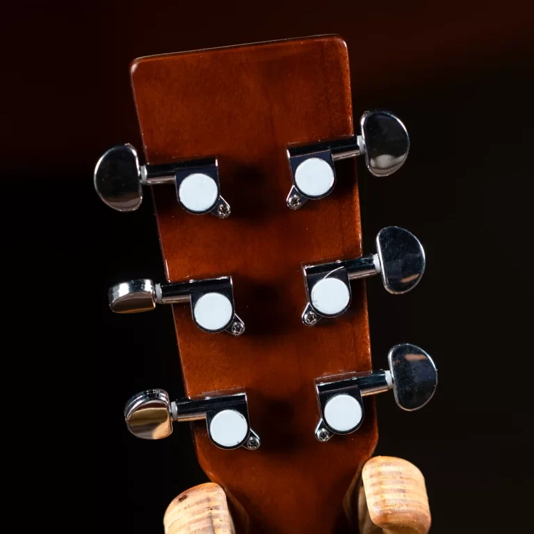 Close-up of a guitar headstock showing six chrome tuning pegs against a brown wooden neck. ขายราคาพิเศษ