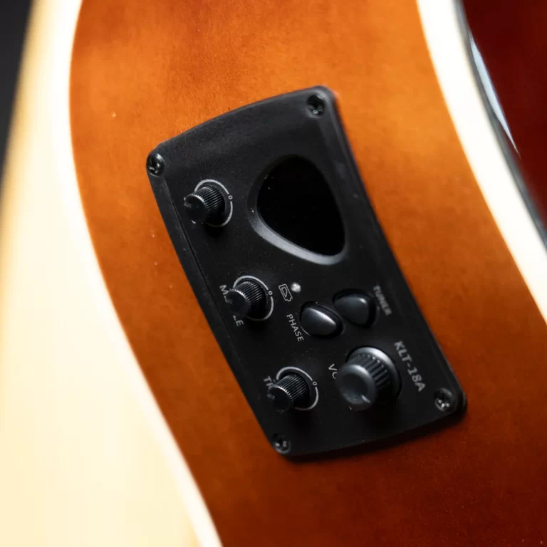 Close-up of an acoustic guitar body showing a black onboard preamp panel with knobs and a soundhole, sunburst finish. ขายราคาพิเศษ