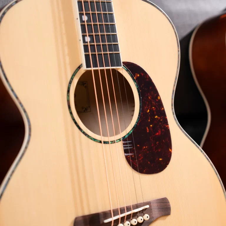 Close-up of an acoustic guitar focusing on the soundhole, strings, and tortoiseshell pickguard. ขายราคาพิเศษ