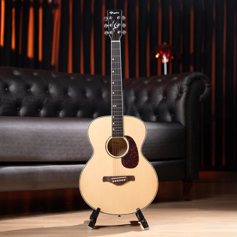 Acoustic guitar on a stand in a cozy lounge with a tufted black leather sofa behind it. ขายราคาพิเศษ