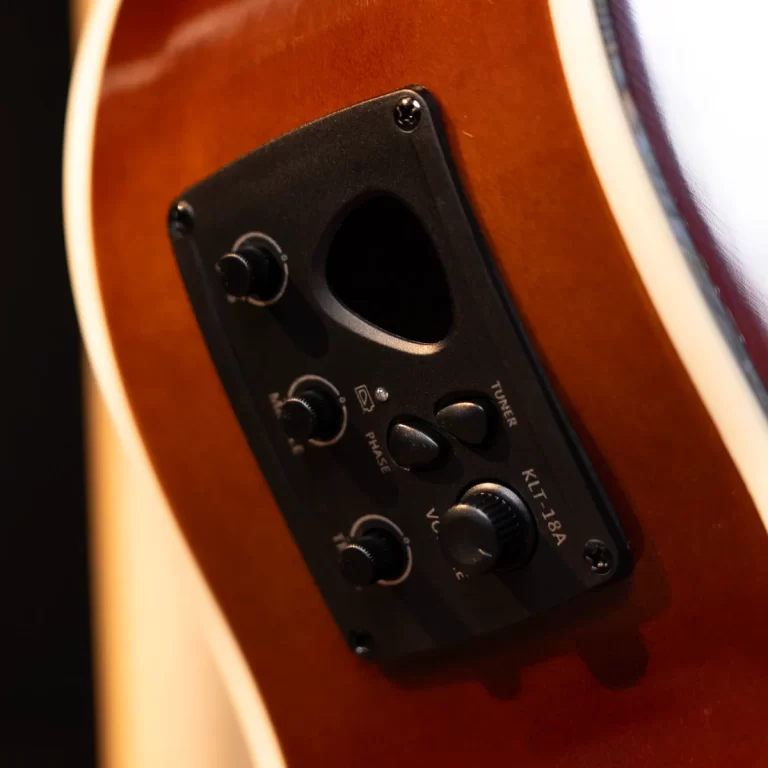 Close-up of an acoustic guitar body with a black preamp/control plate and knobs near the soundhole. ขายราคาพิเศษ