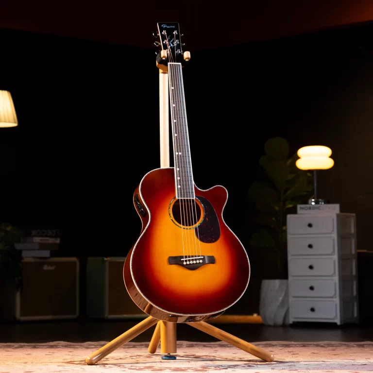 Sunburst acoustic guitar with a cutaway resting on a wooden stand in a dim studio lighting backdrop. ขายราคาพิเศษ