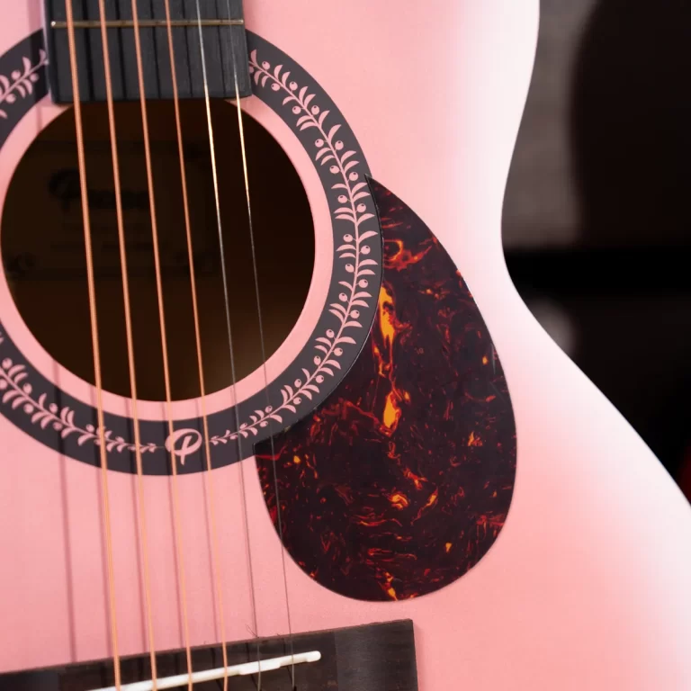 Close-up of a pink acoustic guitar showing the soundhole rosette and tortoiseshell pickguard nearby strings. ขายราคาพิเศษ