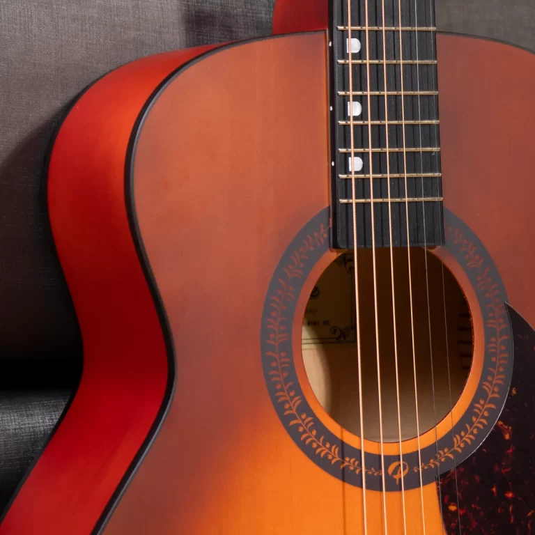 Close-up of an acoustic guitar focusing on the body, soundhole, and fretboard with six strings. ขายราคาพิเศษ