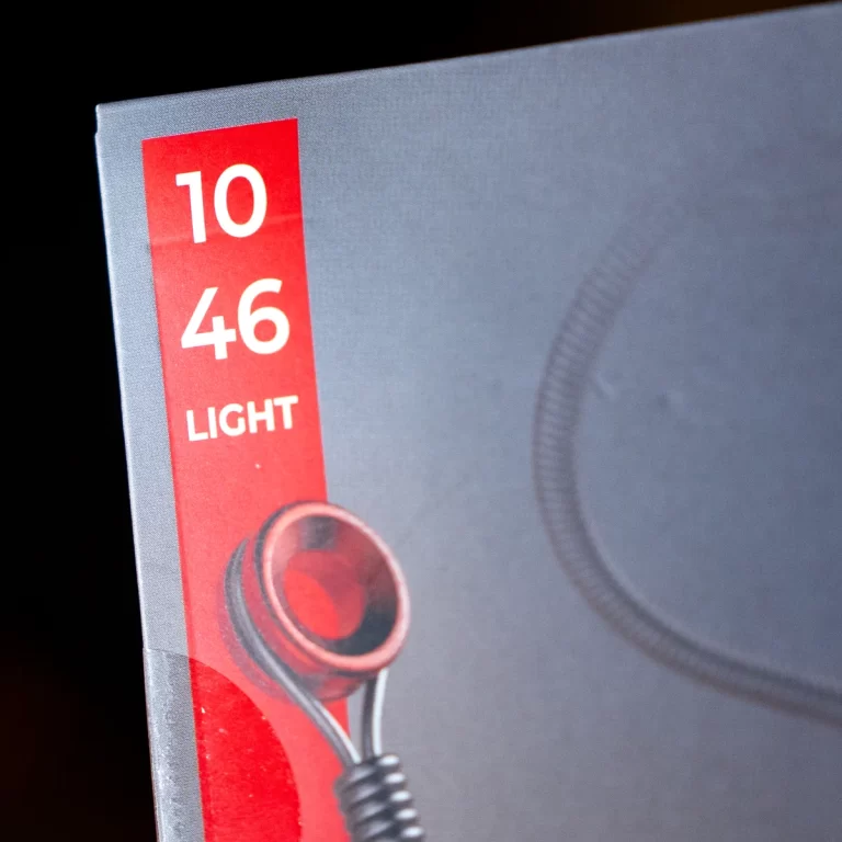 Product box featuring a red vertical label with the numbers 10 46 and the word LIGHT, next to a partial image of a red headphone earpiece. ขายราคาพิเศษ