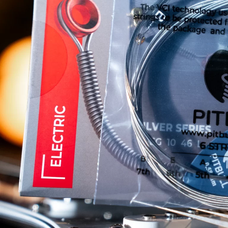 Close-up of product packaging showing a red strip labeled 'ELECTRIC' and a coiled metal cable visible through clear plastic. ขายราคาพิเศษ