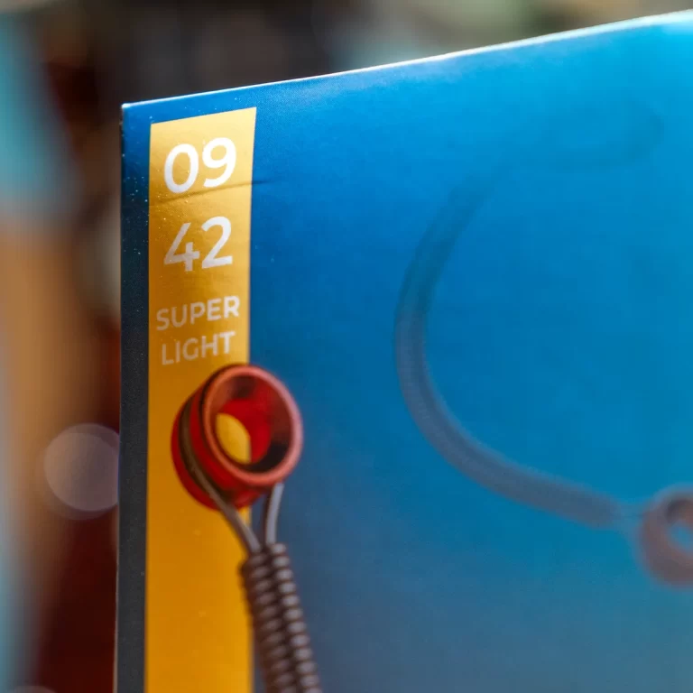 Close-up of a blue device with a vertical yellow label reading '09 42 SUPER LIGHT' and a red circular light socket with a coiled wire. ขายราคาพิเศษ