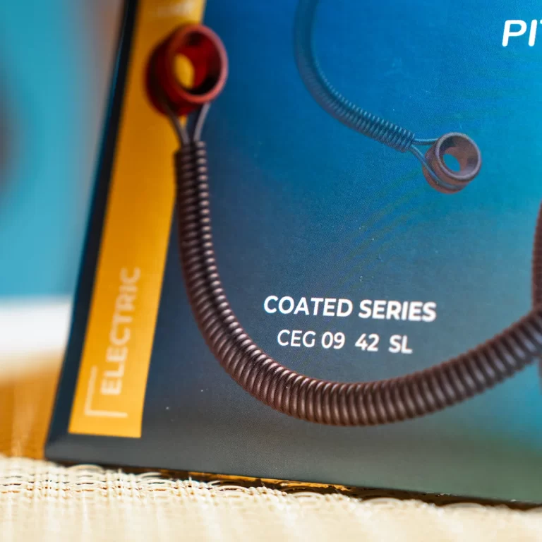 Close-up of blue product packaging reading 'COATED SERIES CEG 09 42 SL' with a black coiled cord and yellow strip nearby. ขายราคาพิเศษ