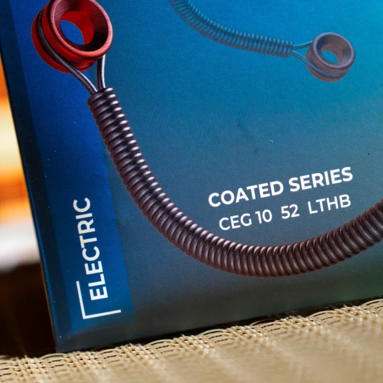 Close-up of blue packaging showing a brown coiled cord draped across the front; text reads 'COATED SERIES' and 'CEG 10 52 LTHB' along with 'ELECTRIC' on the side. ขายราคาพิเศษ