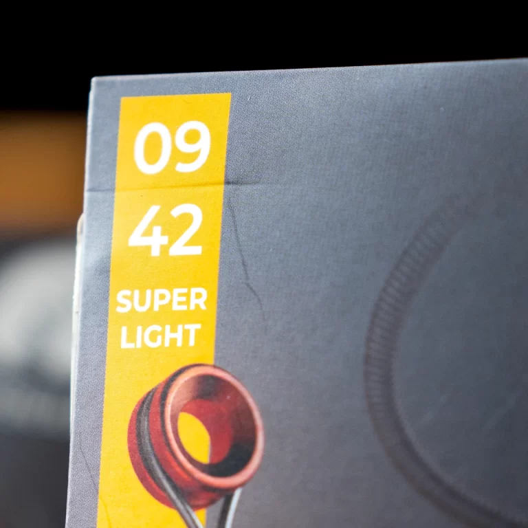 Box with a yellow vertical label showing '09 42' and 'SUPER LIGHT' beside a red earbud image on a gray background. ขายราคาพิเศษ