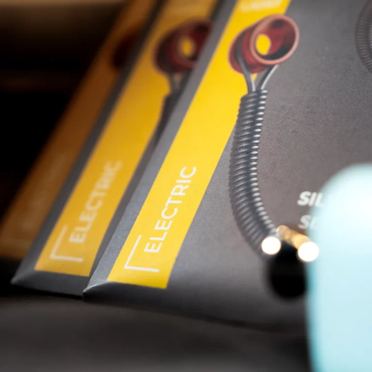 Close-up of black and yellow product packaging labeled ELECTRIC, featuring a coiled cord illustration between the boxes. ขายราคาพิเศษ