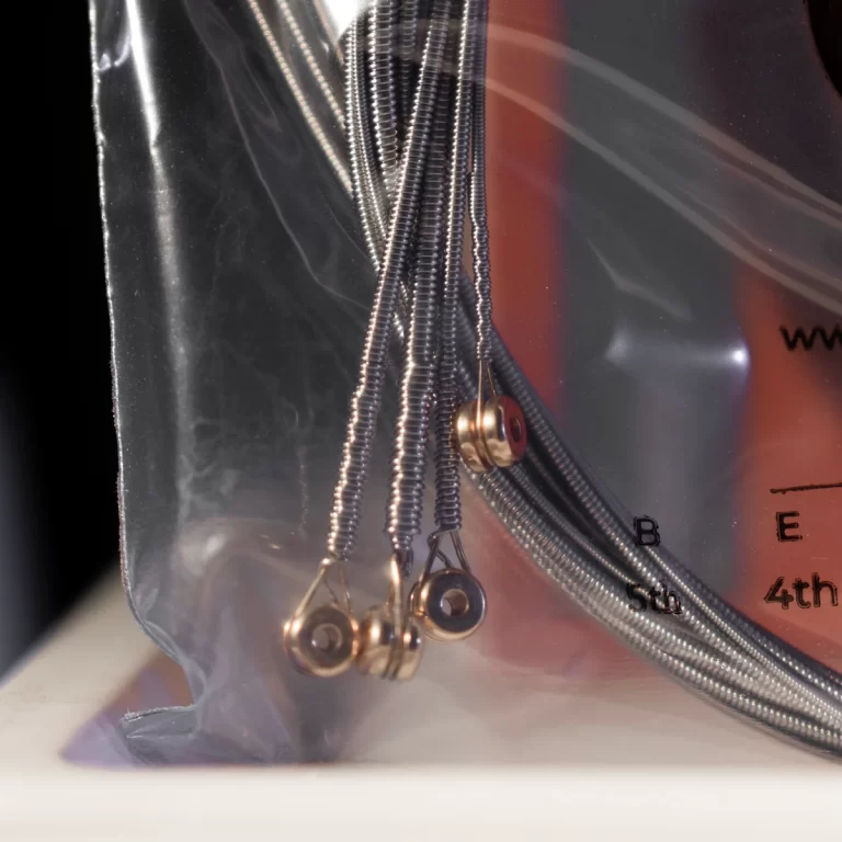 Close-up of several metal coil springs with small loop ends inside a clear plastic bag beside a red dial labeled 4th/5th. ขายราคาพิเศษ
