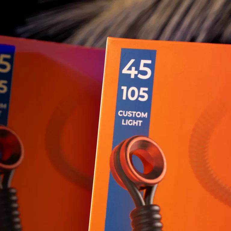 Boxed product packaging showing a ‘Custom Light’ with model numbers 45 and 105 on a blue strip against an orange background; coiled light accessory visible near bottom edge. ขายราคาพิเศษ