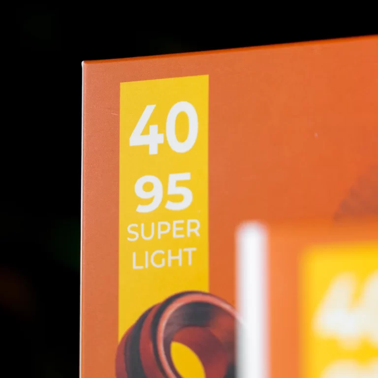 Close-up of an orange product box with a yellow vertical label reading '40 95' and 'SUPER LIGHT'. ขายราคาพิเศษ