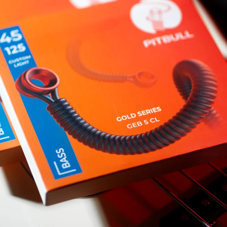 Close-up of orange product box showing a black coiled cord and blue 'BASS' label, Gold Series GEB 5 CL ขายราคาพิเศษ