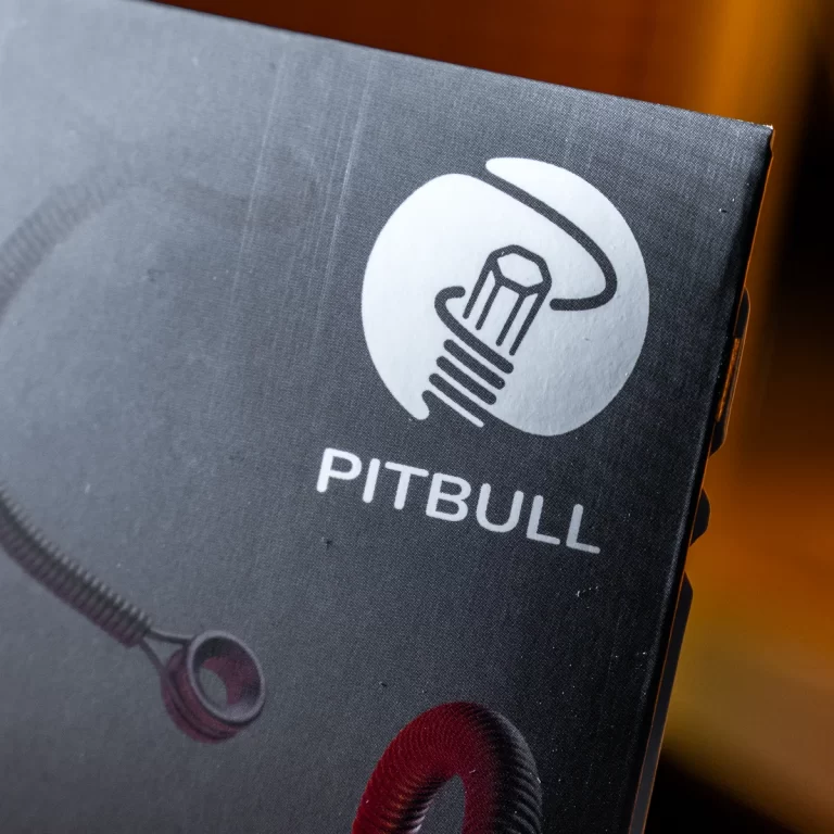 Close-up of a dark packaging box showing the Pitbull brand logo (circle with abstract graphic) and the word PITBULL underneath. ขายราคาพิเศษ