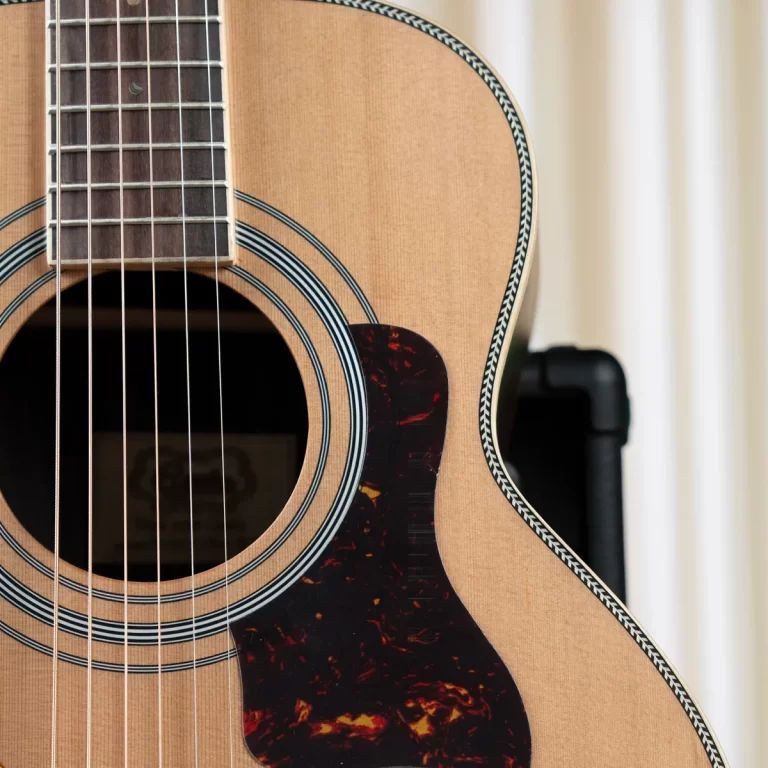 Close-up of an acoustic guitar showing the soundhole, strings, and tortoiseshell pickguard. ขายราคาพิเศษ