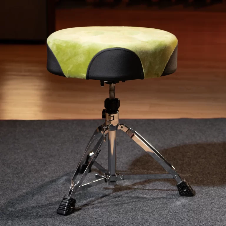 Padded drum throne with lime-green and black upholstery on a chrome adjustable tripod base on a carpeted floor. ขายราคาพิเศษ