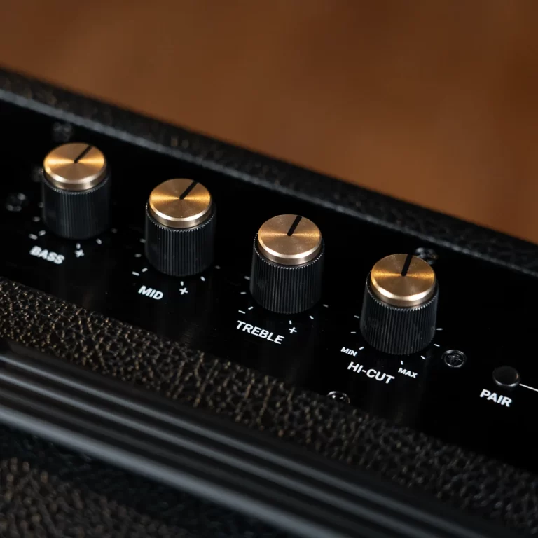 Close-up of four brass-tone control knobs on a black guitar amp panel labeled Bass, Mid, Treble, and Hi-Cut. ขายราคาพิเศษ